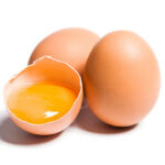 Tres huevos, hay un huevo que esta cascado y está la yema naranja del huevo. Los otros dos están enteros.